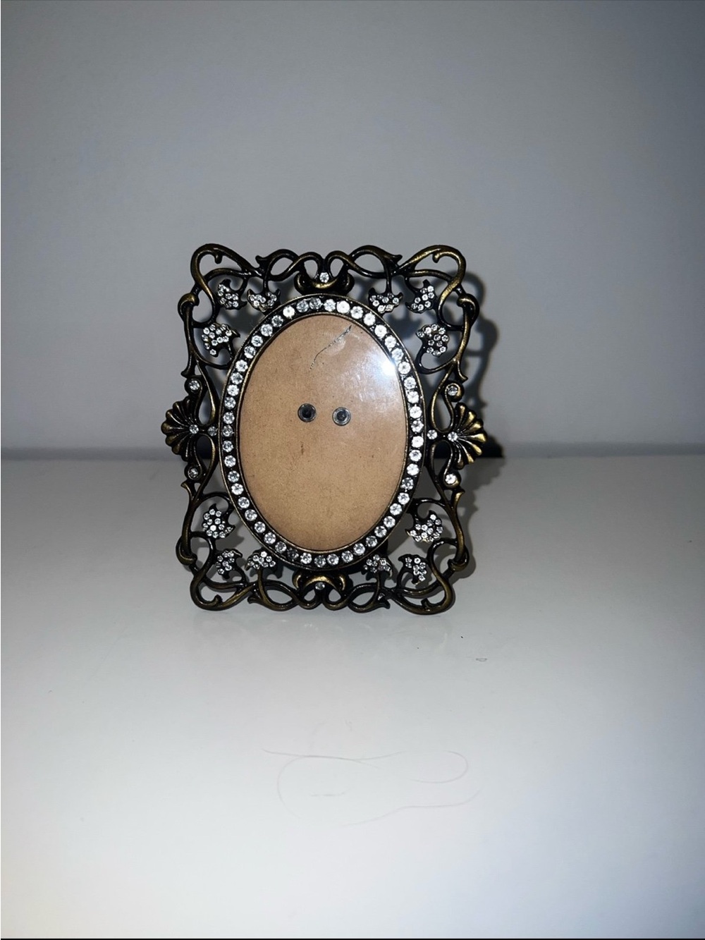 Vintage picture frame features an ornate, filigree metal border